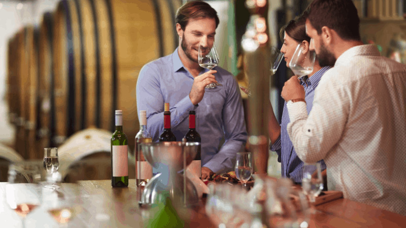 Luxury winter getaways should always include good food and drink. Here, you see two men and a woman doing a wine tasting