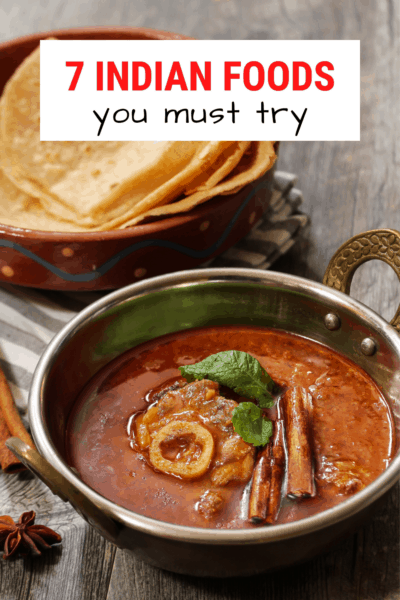 Rogan josh accompanied by naan flatbread in the background. Text overlay says "7  Indian foods you need to try."