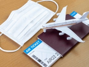 passport with an air ticket inside it. mask. model airplane