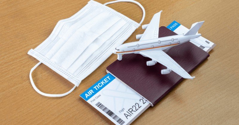 passport with an air ticket inside it. mask. model airplane