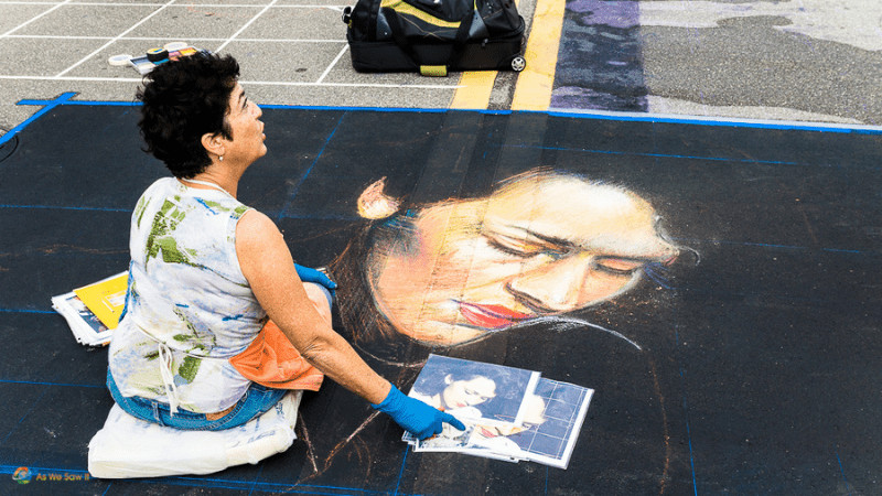 Woman copying a photo in chalk onto the street in Sarasota florida