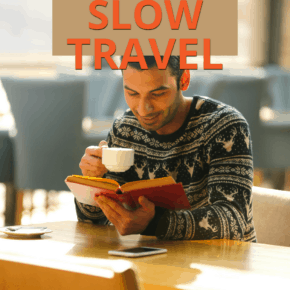 Smiling man drinking coffee while reading a book. Text overlay says "the new way b to travel the world: slow travel."