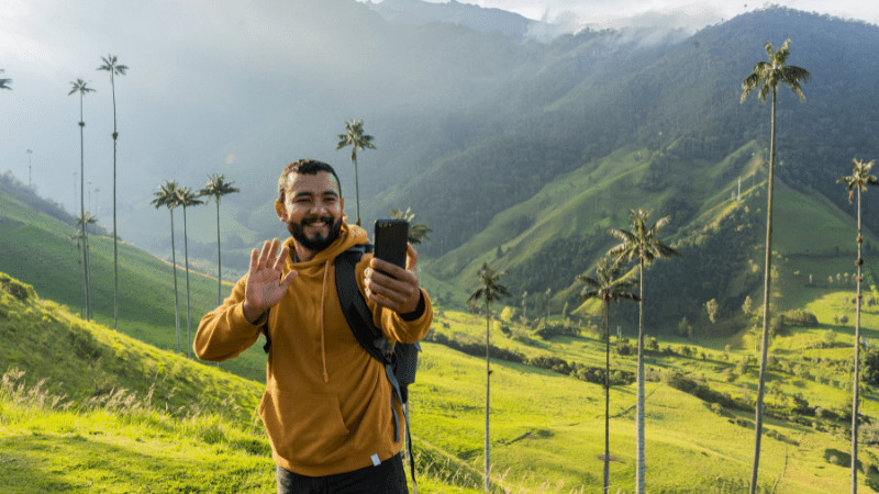 Man doing travel vlogging in front of rice terraces with palm trees in background