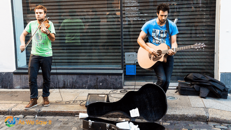 Two buskers on the street playing guitar and fiddle,
