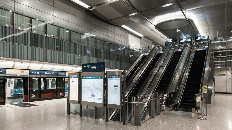 Escalators and signs at a Singapore MRT station