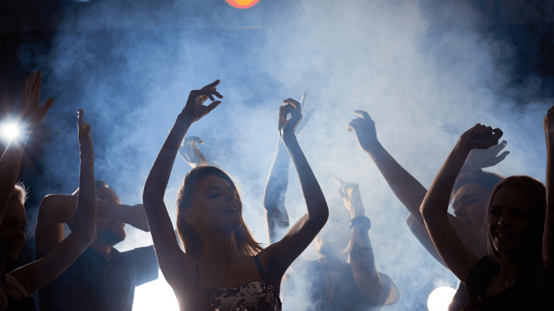 People dancing in a smoke-filed room