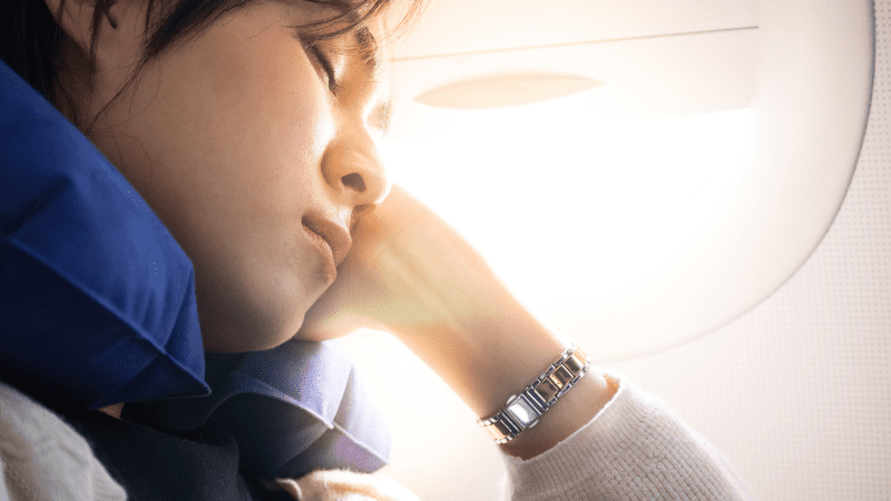 Woman sleeping in front of an airplane window