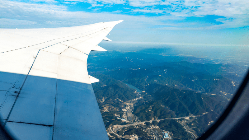 View of the ground from an airplane. Wing in foreground. One of the best things to do on a plane is look out a window.