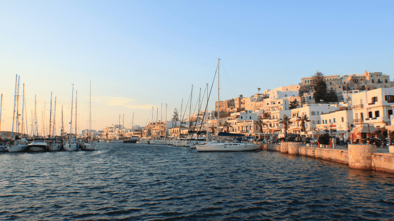 boats in the water next to a town on Naxos Greece