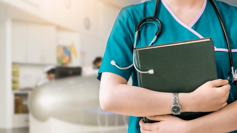 torso of a medical professional holding a clipboard