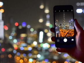 Hand holds phone taking photo of Burj Khalifa instagram spot in Dubai
