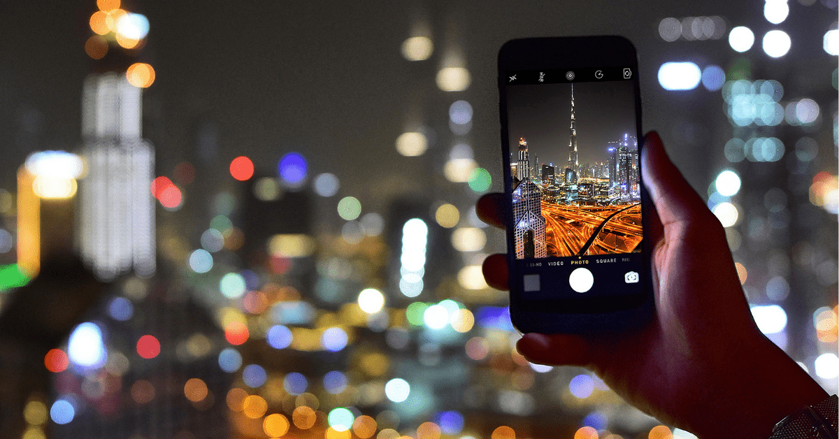 Hand holds phone taking photo of Burj Khalifa instagram spot in Dubai