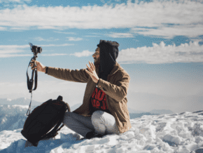 Person sitting on the beach vlogging with cell phone