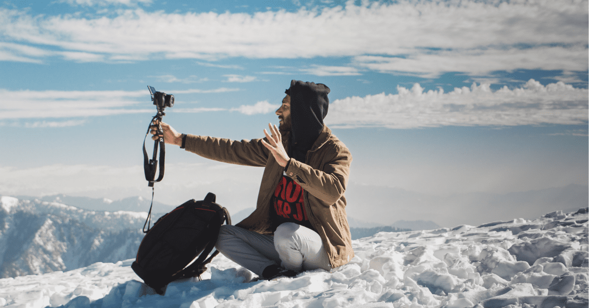 Person sitting on the beach vlogging with cell phone