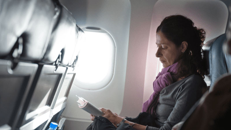 woman reading a book on a pland