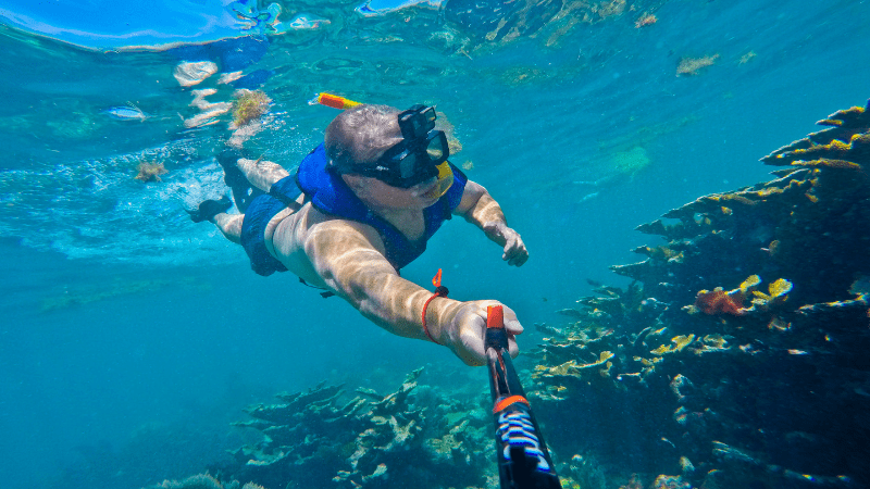 Person holding a selfie stick underwater