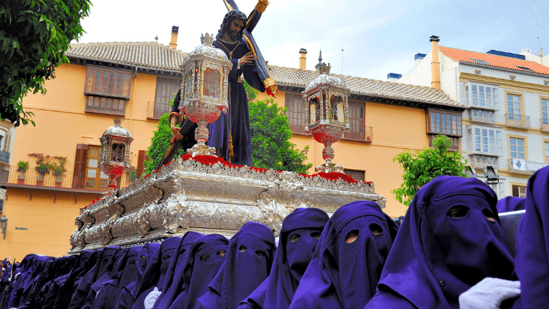 Hooded people carrying a fload in Spain during Holy Week festival