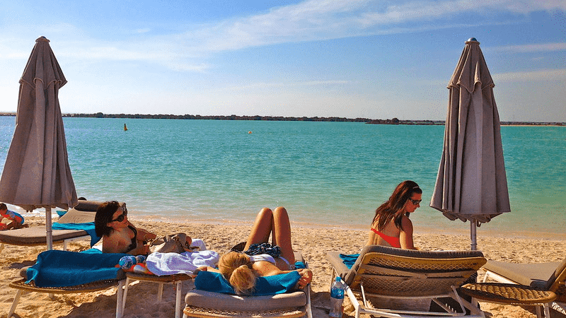 People on lounge chairs at Yas Beach