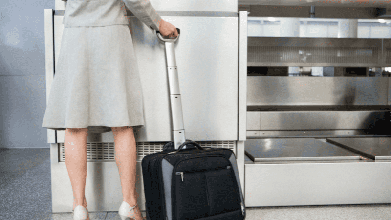 Here you see a woman with a very small carryon at an airline check-in counter. She knows how to save money on travel by packing light. 