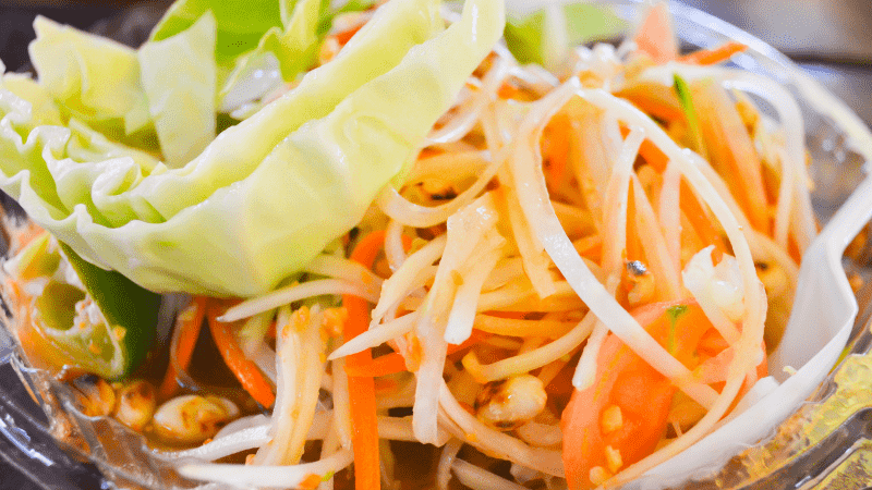 closeup of cabbage and vegetables in som tam green papaya salad