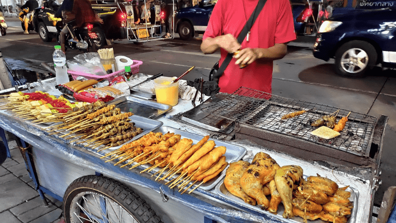 Assorted Thai street foods for sale on a vendor's cart