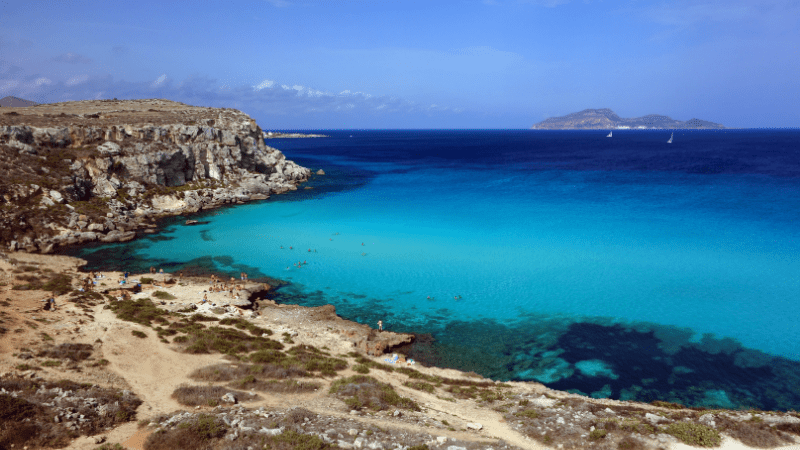 bright blue water off the coast of the beach in Cala Rossa Favignana
