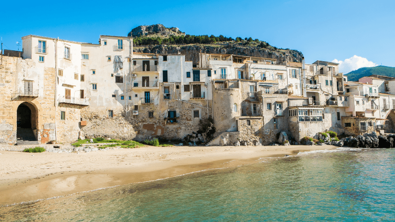 waterfront buildings along the beach in Cefalu. Sea in foreground