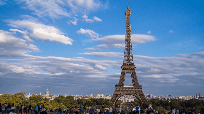 Eiffel tower and Paris skyline with people in the foreground. 