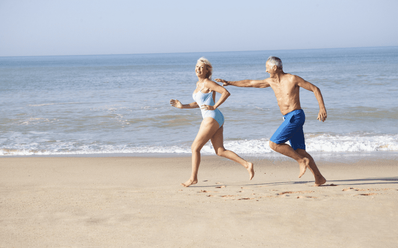 man and woman running on the beach