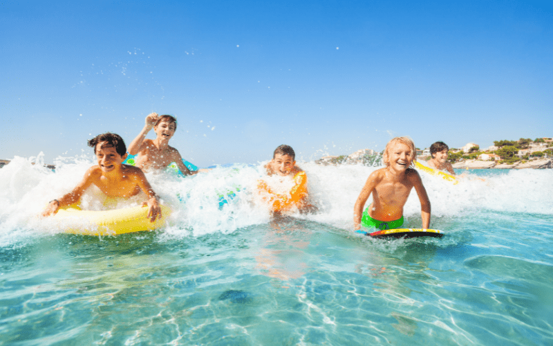people using body boards in the waves