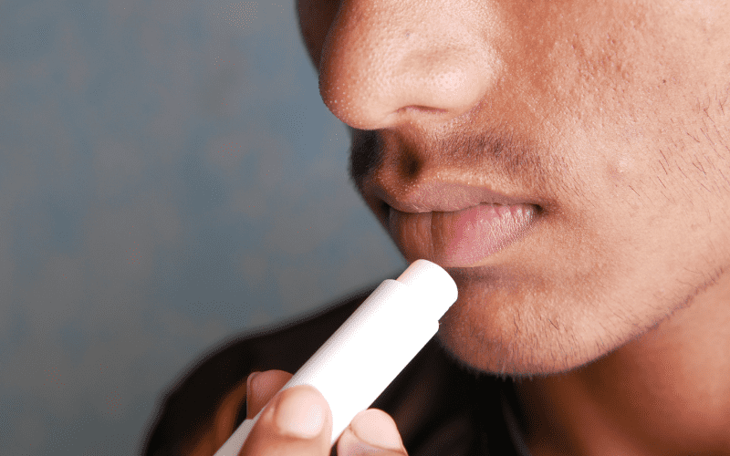 man applying lip balm