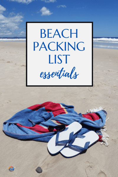 Red & blue towel and sandals on a beach.  Text overlay says "beach packing list essentials."