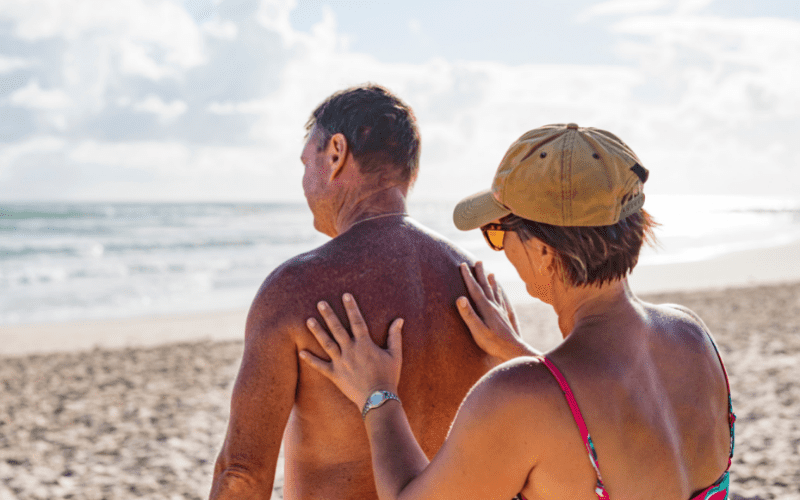 woman applying sunscreen to a man's back