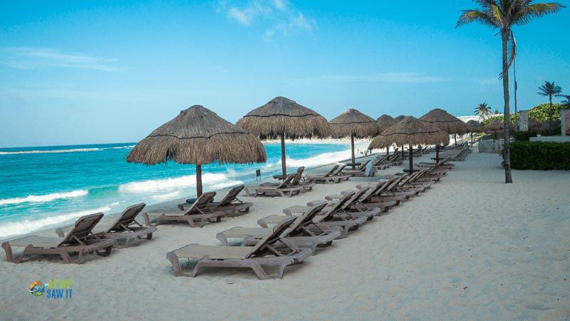 Line of umbrellas and lounge chairs on a Caribbean beach in Cancun Mexico