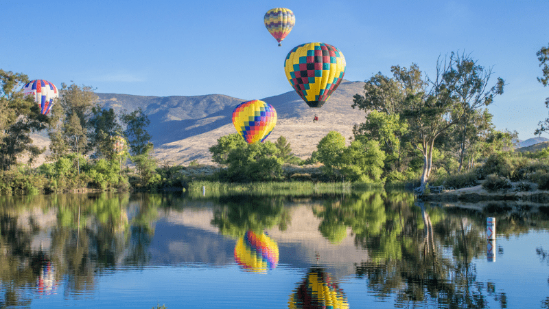 hot air balloons flowating over water