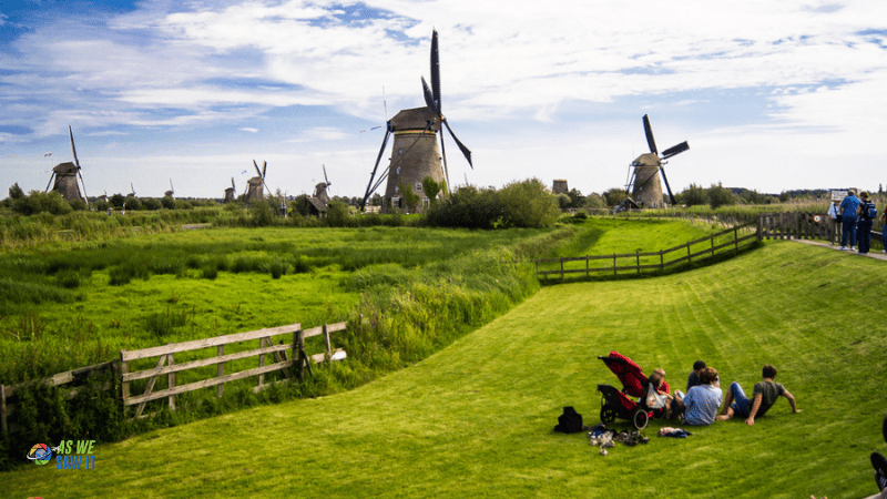 people on the grass near windmills in Kinderdijk Netherlands