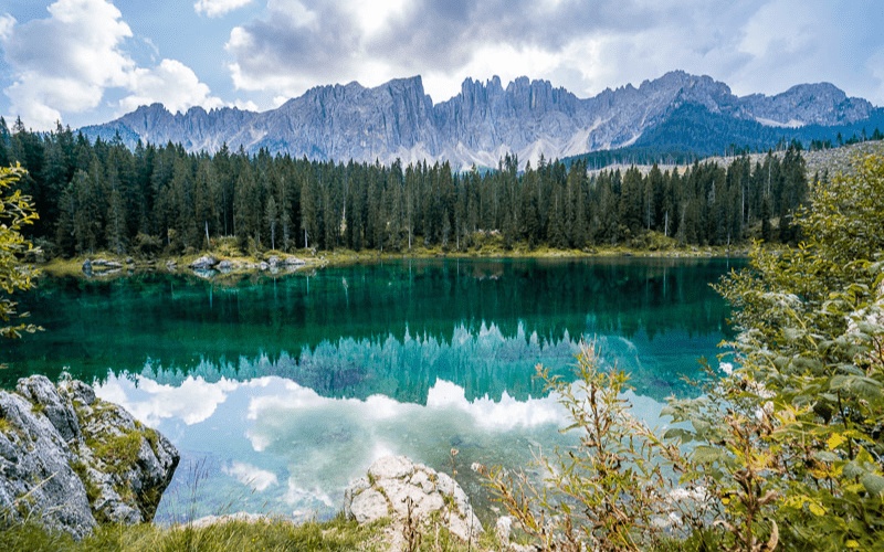 Clouds and mountains reflected in the waters of Lago di Carrezza, Dolomites