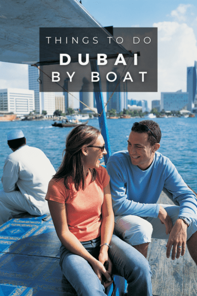 Couple sitting on a boat and looking at each other. Text overlay says "things to do dubai by boat"