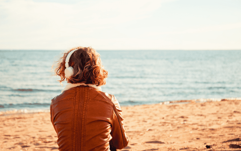 person wearing earphones at the beach