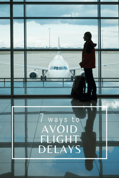Person in an airport looking at a plane out the window. The text overlay says "7 ways to avoid flight delays."