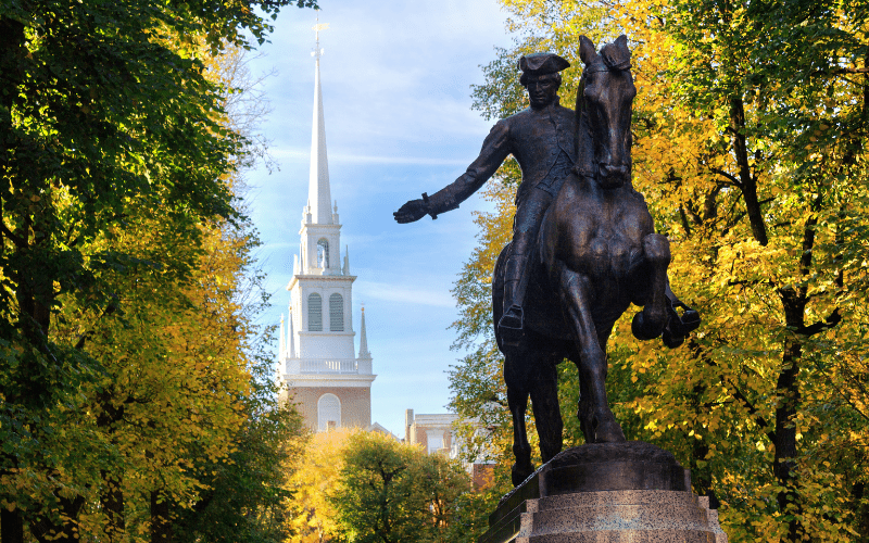 Statue of Paul Revere on a horse, with steeple of Boston Old North Church in background. Weekend in Boston