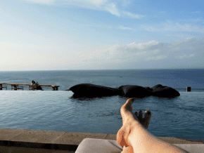 luxury experiences in Bali - feet on a lounge chair with pool in background