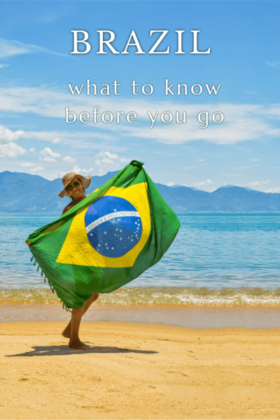 Person on the beach holding a Brazil flag