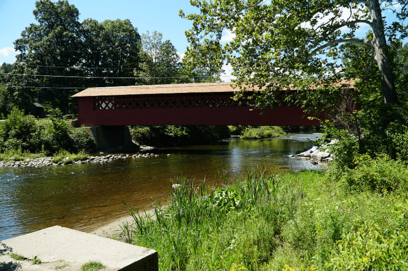 A red covered bridge over a river in Vermont