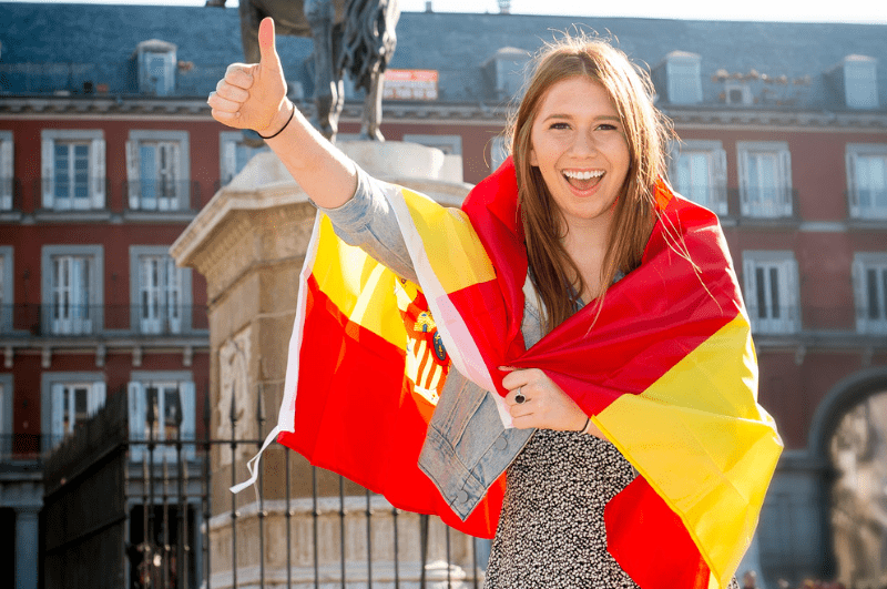 woman holding a thumbs up and wearing the Spanish flat