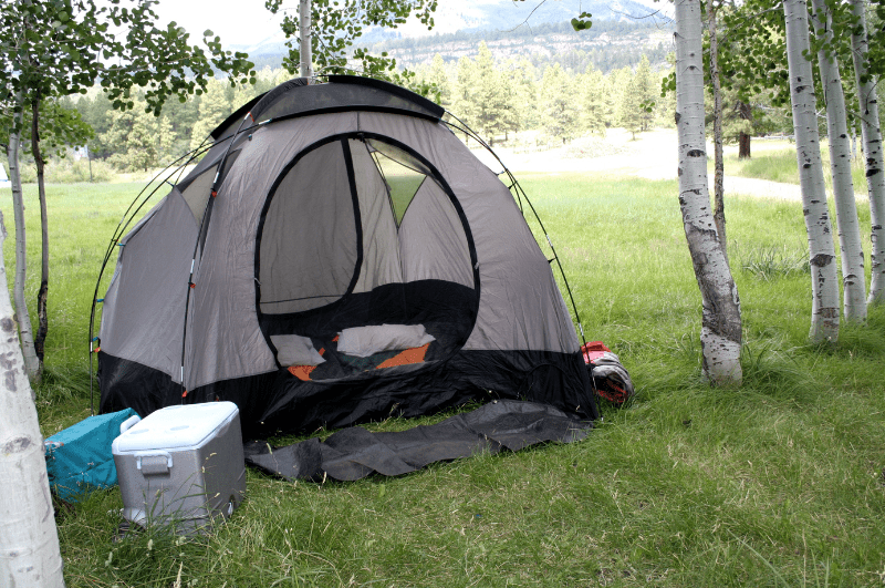 A campsite with tent, cooler, and sleeping bags