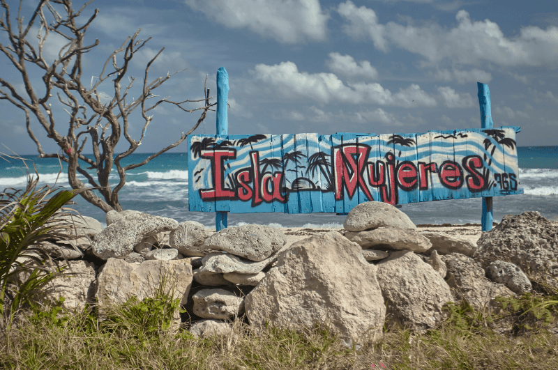 sign on the beach that says Isla Mujeres