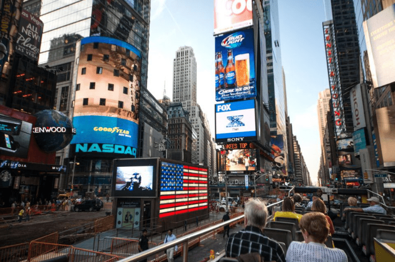 Open top hop-on-hop-off tour bus going through Times Square