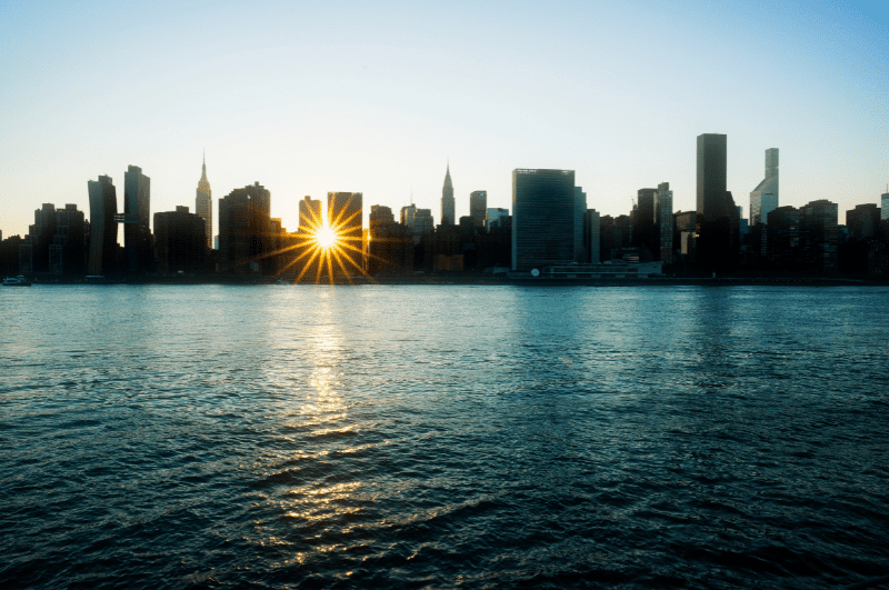sun setting behind New York City