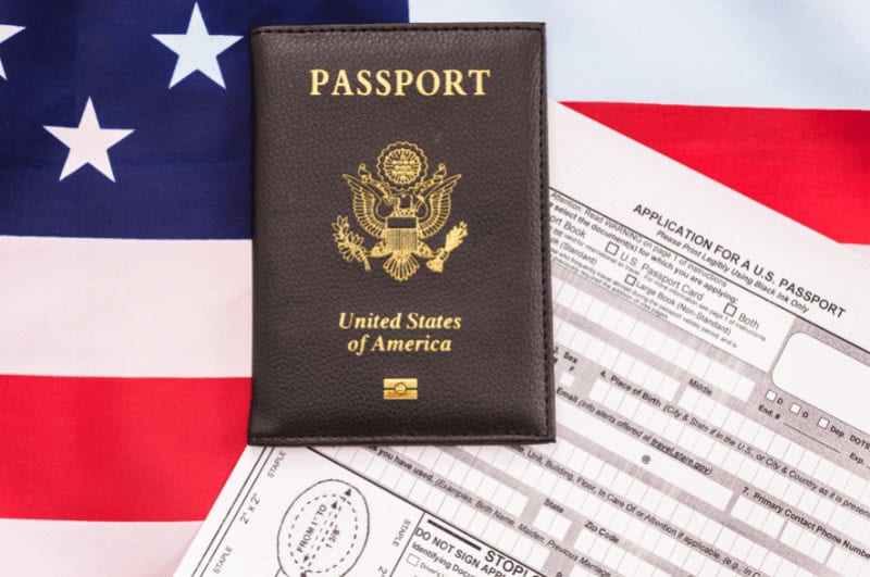 United States passport on top of a passport application form and USA flag